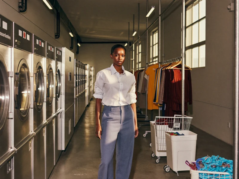 Vue d'ensemble d'un atelier industriel de blanchisserie, machines et rails sous la lumière du jour